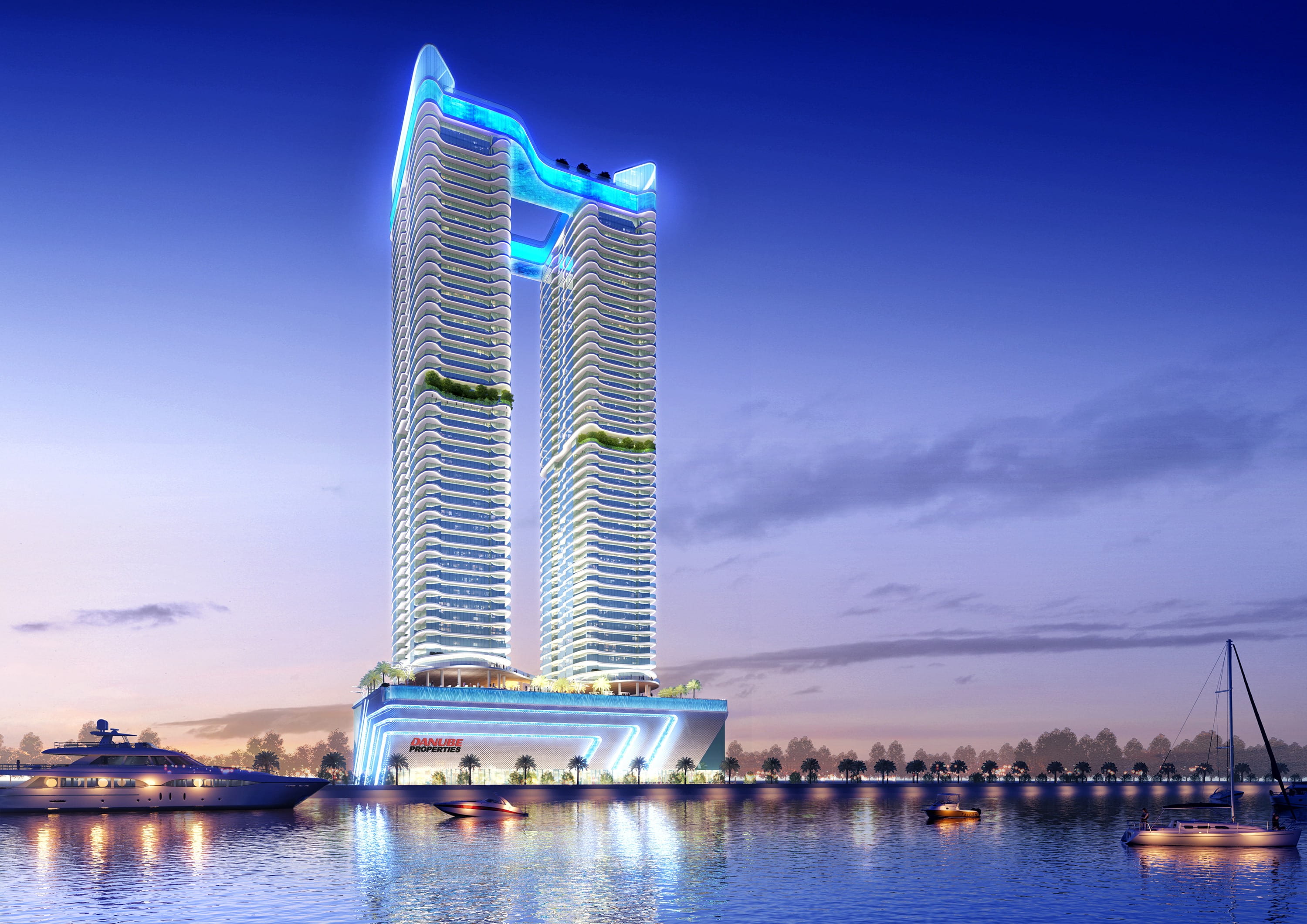 Danube Oceanz twin towers illuminated at night with marina